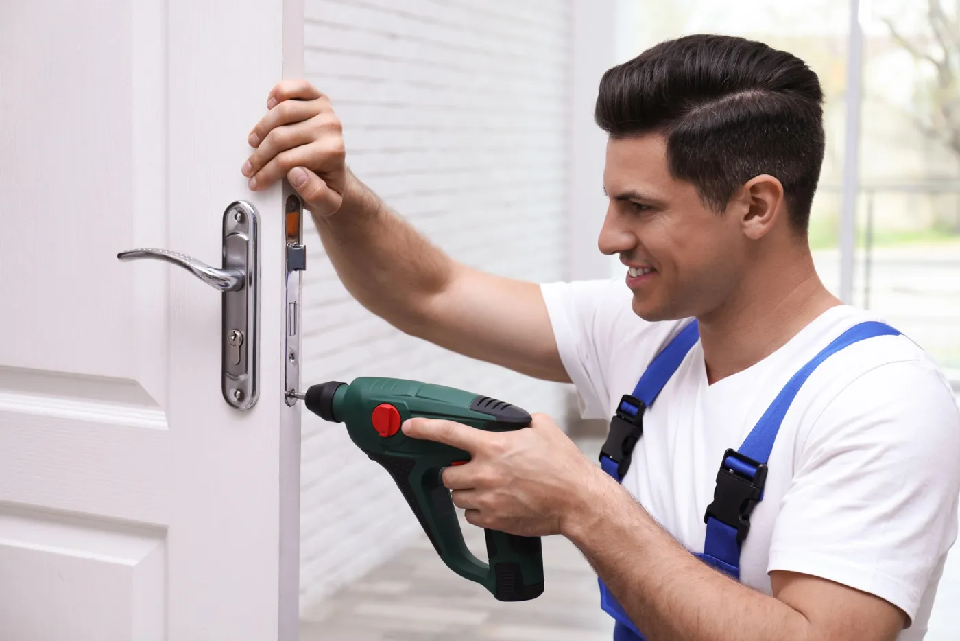 Artisan serrurier installant une poignée de porte à Carrières-sous-Poissy